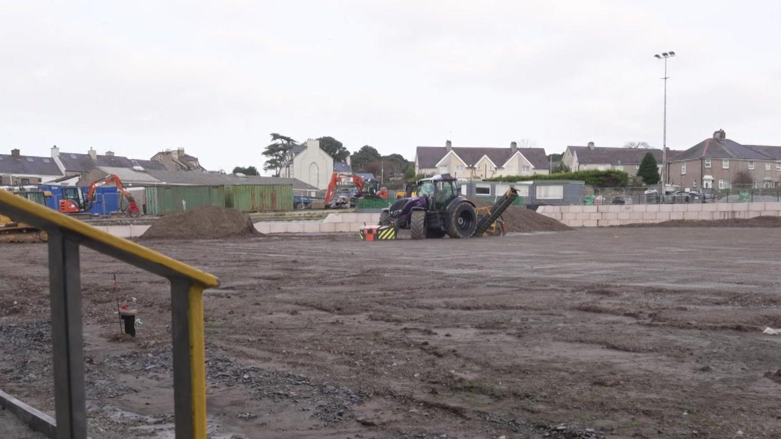 Tractor ar gae'r Oval o flaen y teras ble mae'n fwriad i godi eisteddle newydd