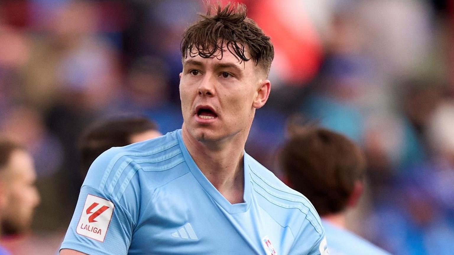 Jorgen Strand Larsen celebrates a goal by pulling at the badge on his light blue Celta Vigo shirt