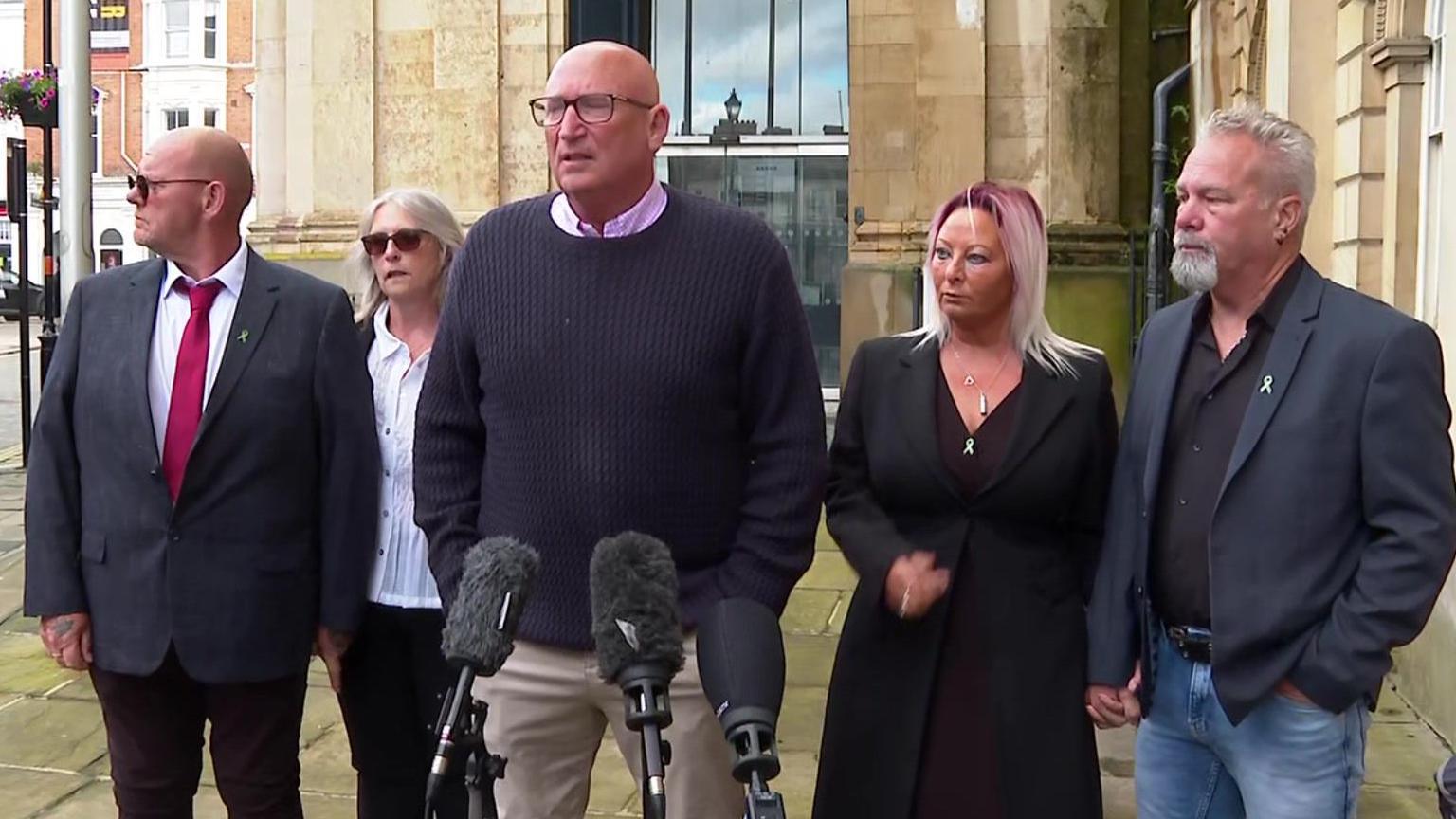 Tim Dunn and Charlotte Charles standing in front of microphones in a street