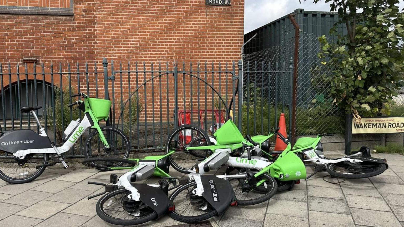 Four out of a group of five dockless e-bikes operated by Lime are laying on their sides with poor parking like this are among the reasons Brent Council has threatened to ban them from the borough 