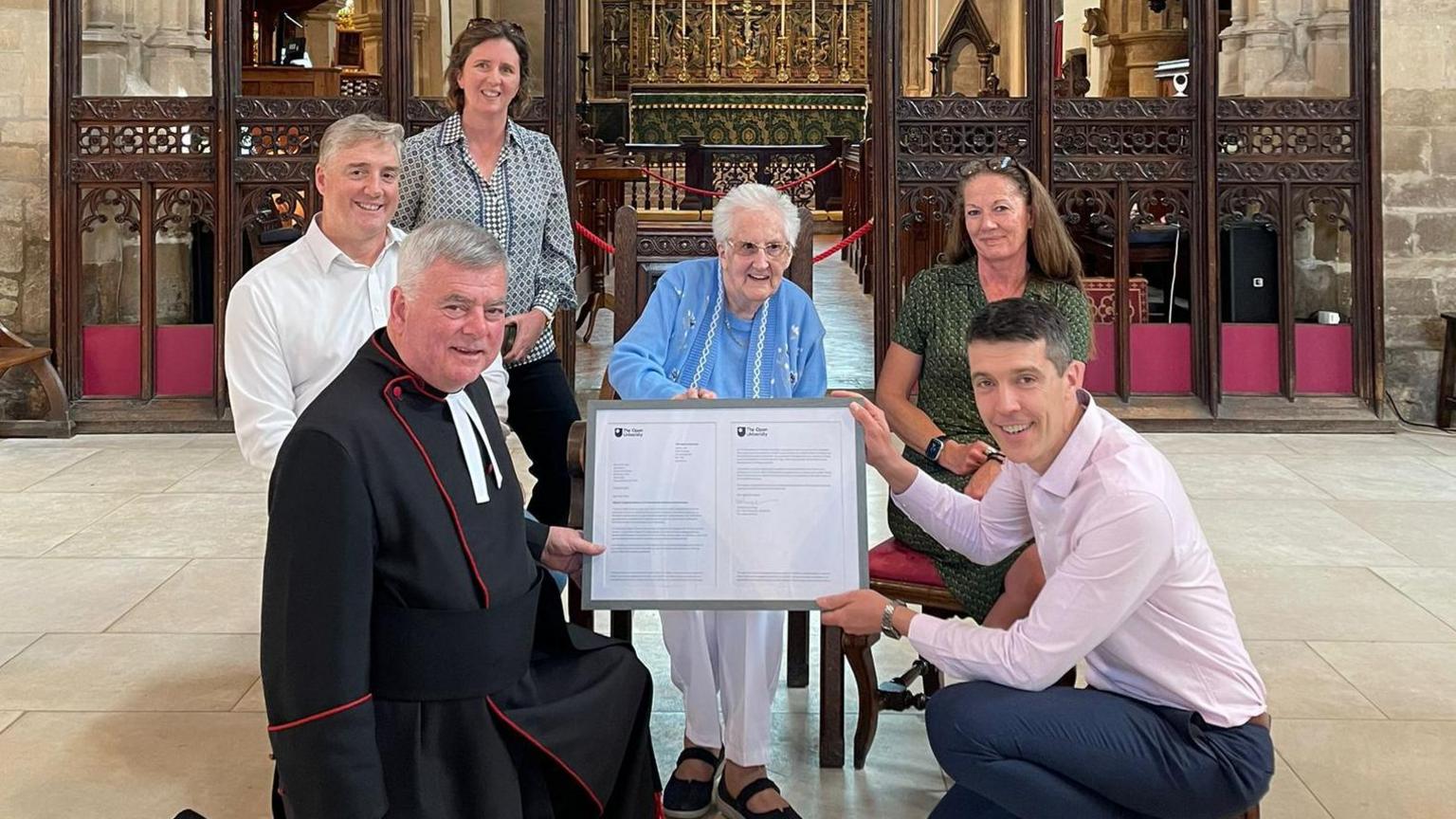 Lucille Terry being presented with a framed letter in a church