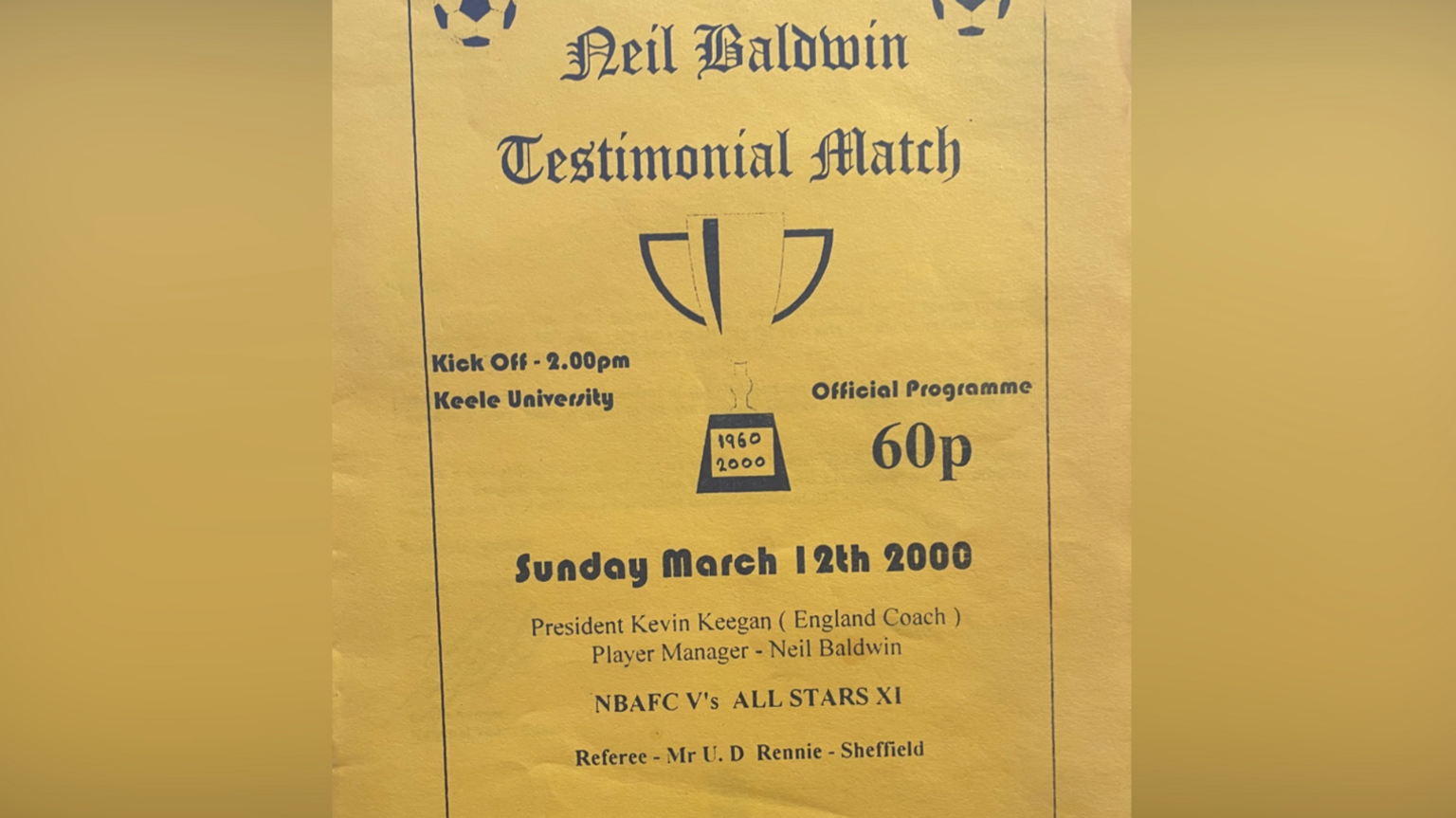 The match programme including the venue, Keele University, and the price of 60p. The page includes an image of a trophy with the years 1960 and 2000 at the bottom if it.