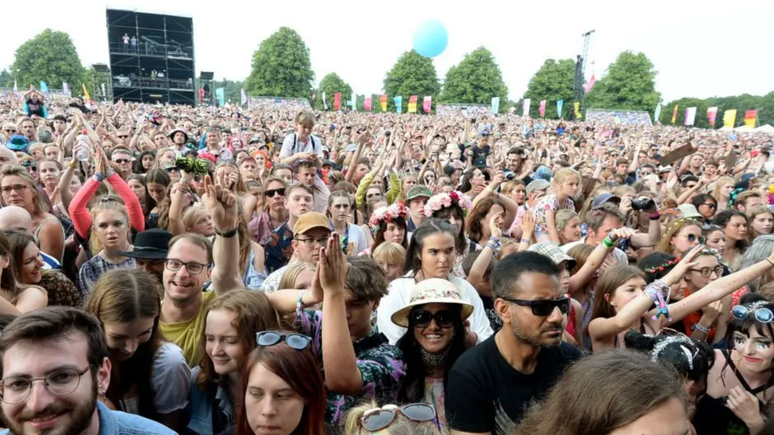 A crowd of thousands of people standing in front of a stage at Latitude Festival