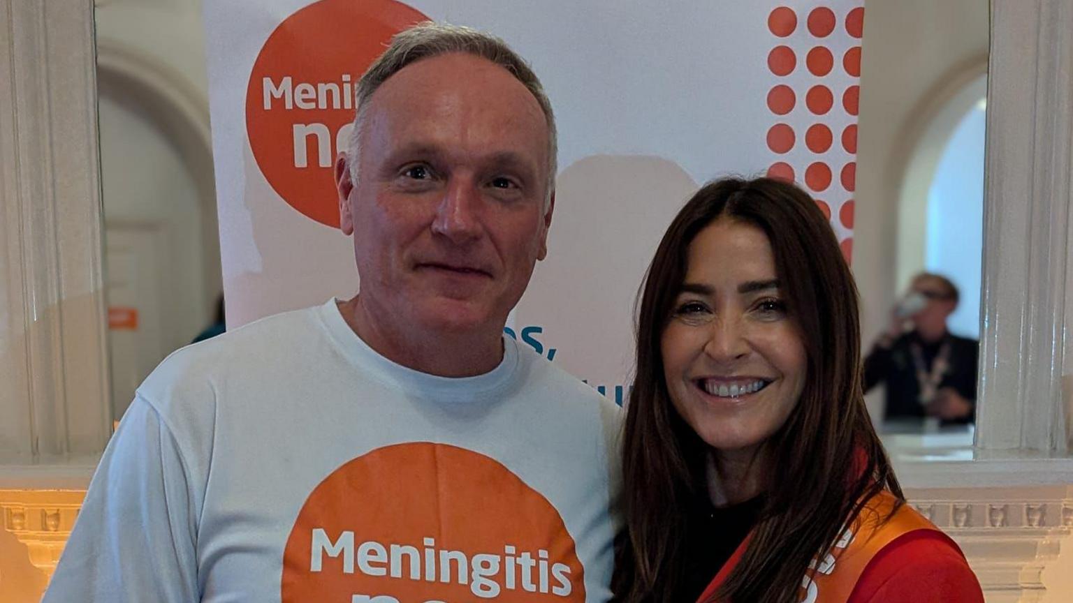 Paul Gentry on the left in a charity t-shirt, looking into the camera with short grey hair, next to Lisa Snowdon on the right, who is also looking at the camera and has long dark hair.