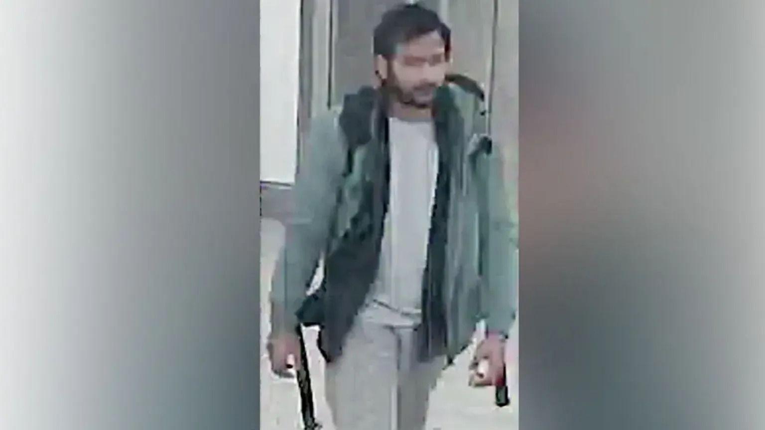 A CCTV picture of the murder suspect Pankaj Lamba wearing a green jacket, a backpack, pale trousers and top. He has a beard and black hair