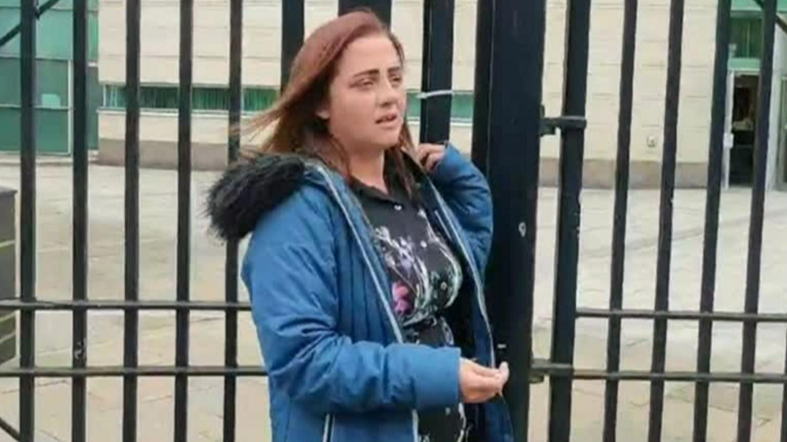 Jade Dempsey in mid-shot walking past security barrier outside Belfast Crown Court