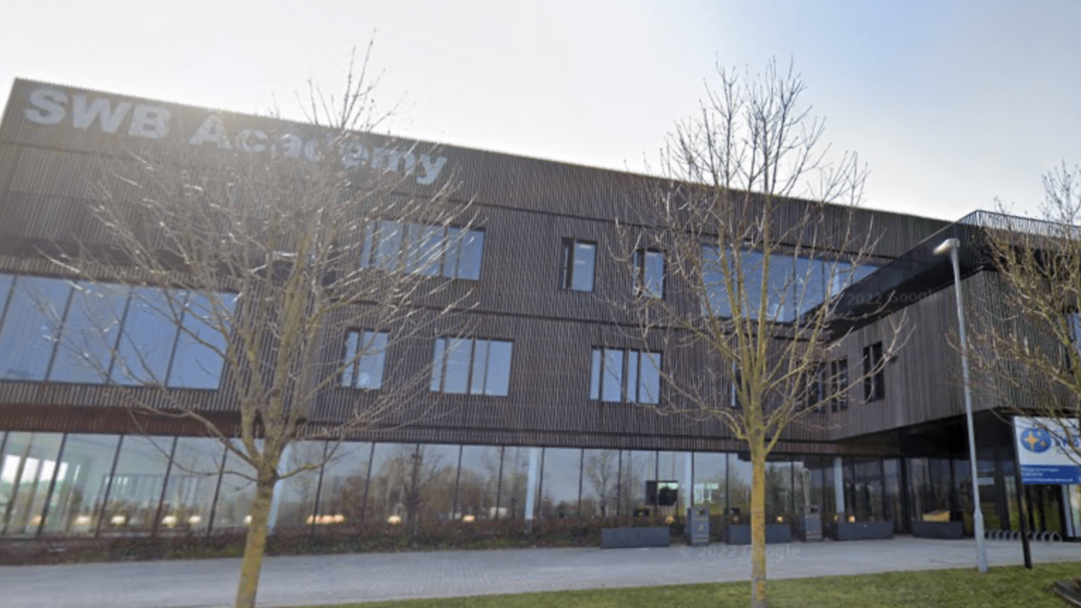 The modern front of Ormiston SWB Academy in Wolverhampton with a large SWB Academy sign in white lettering along the edge of the roof