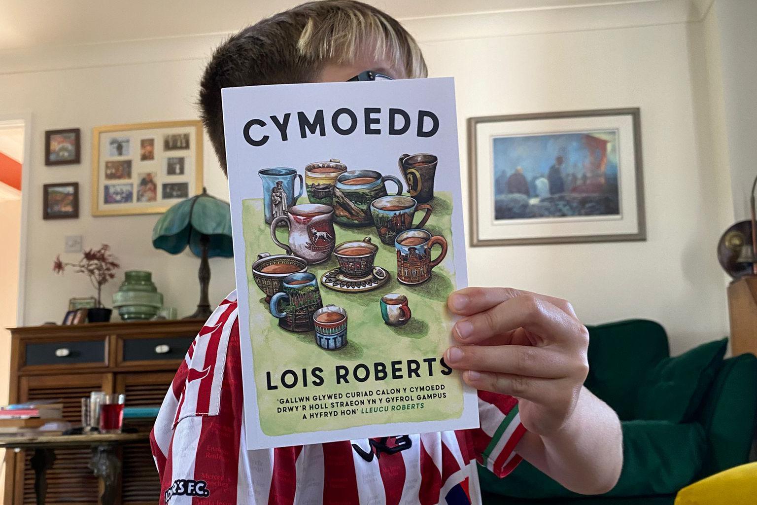 Mab Lois yn dal ei llyfr