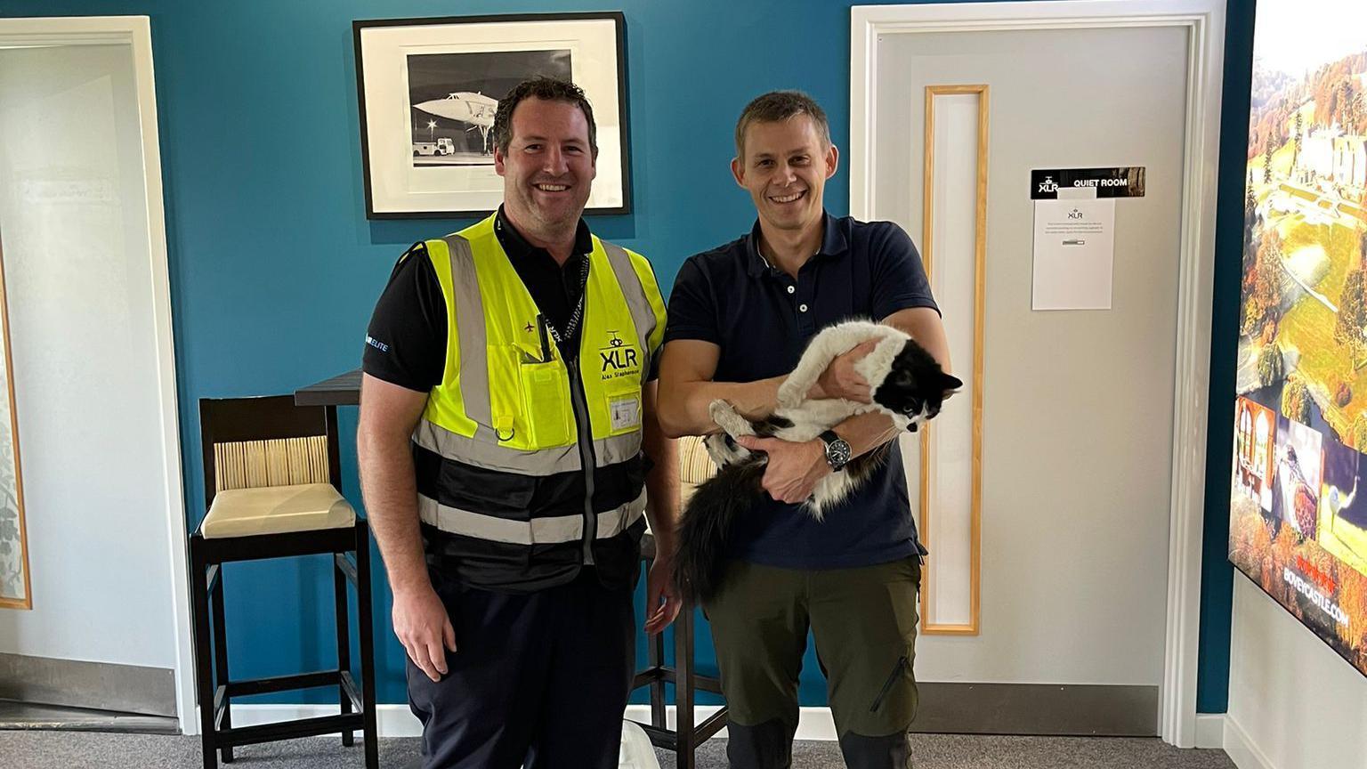 Ted the cat with Exeter airport employee Alex Stephenson and his owner Rich Fleming