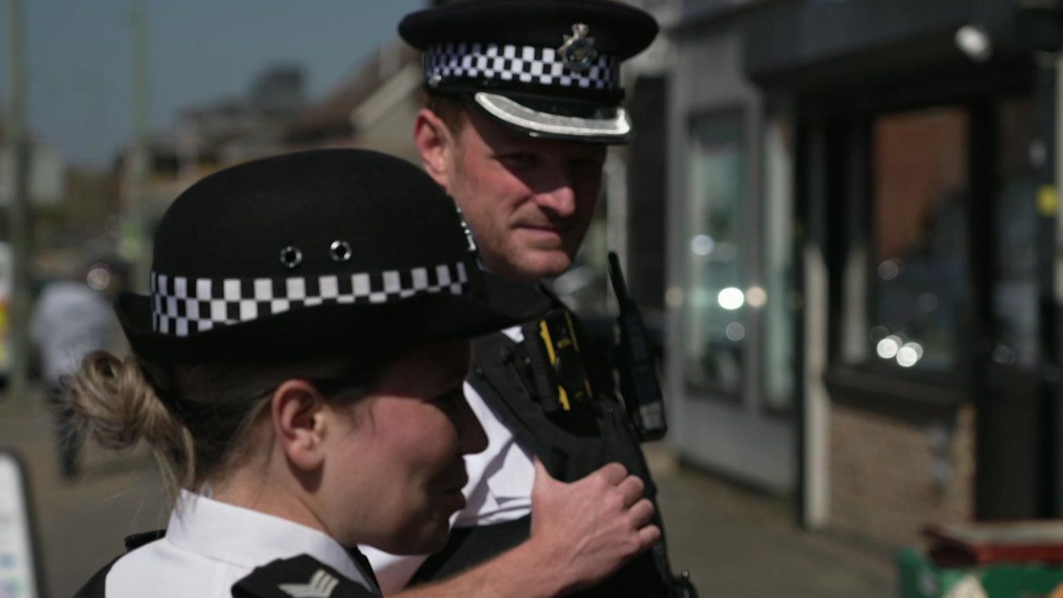 Two police officers on the Safer Neighbourhood team on patrol in the street