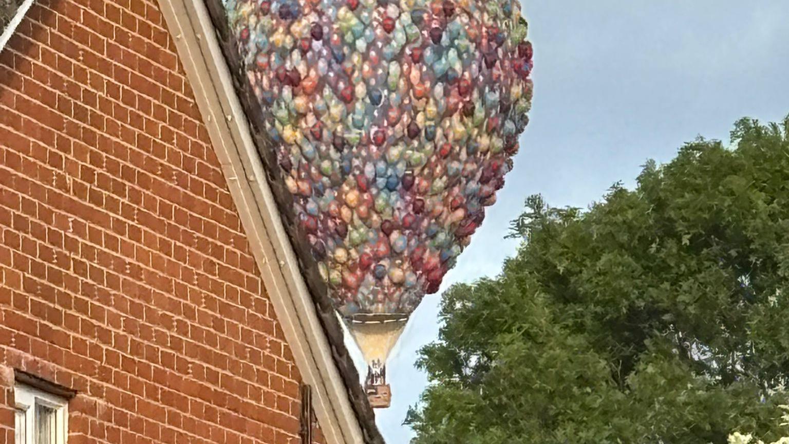 The Disney 'Up' style balloon was pictured peering through houses