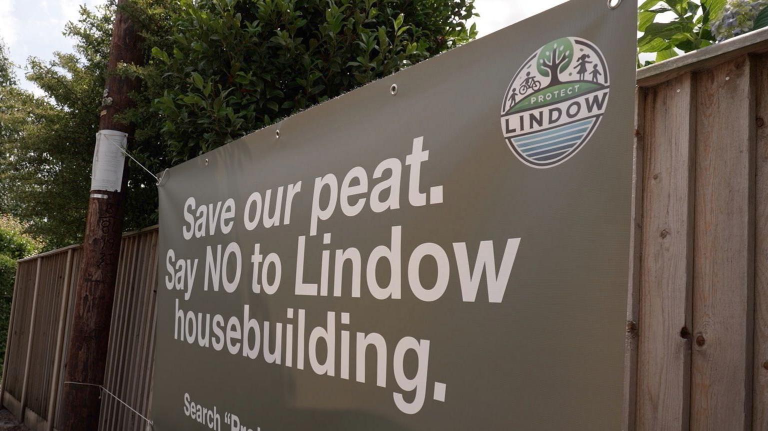 A large grey banner banner with white writing on it which reads: "Save our peat. Say NO to Lindow housebuilding."