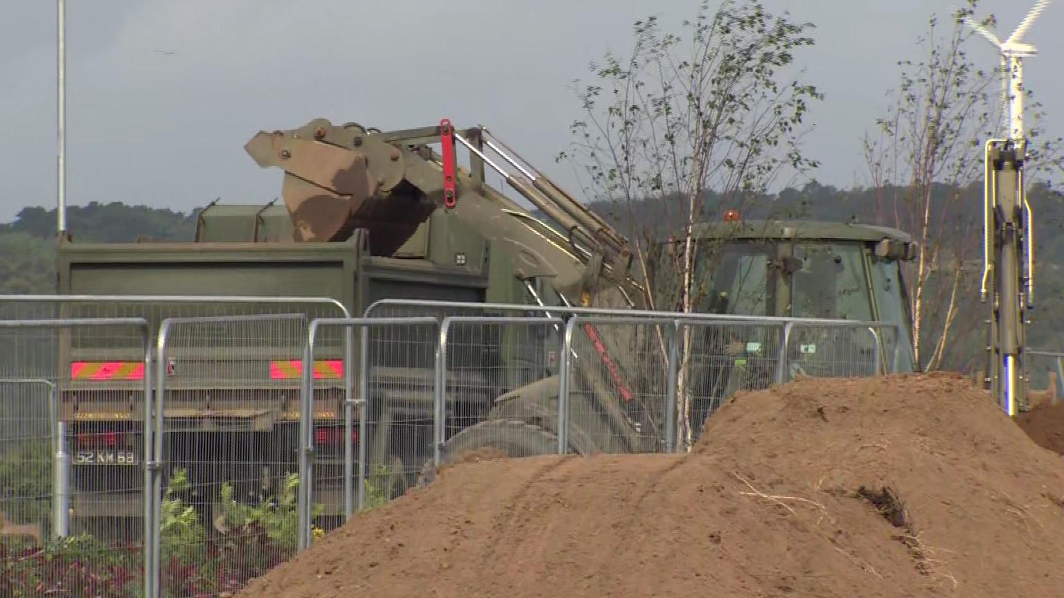 Digger pouring sand into truck