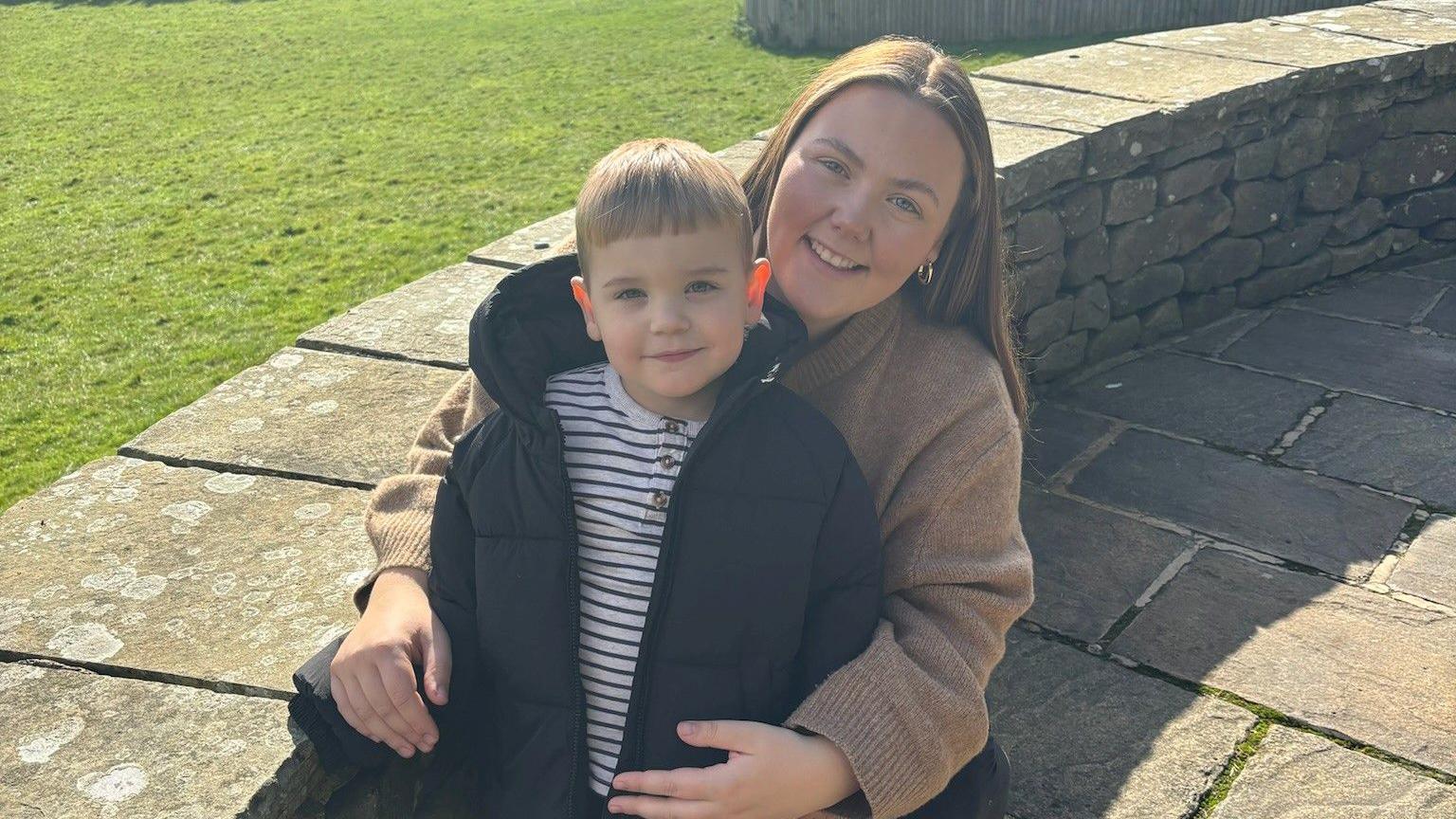 Millie Hope - who has long brown hair - and her now four-year-old son Albie are smiling broadly at the camera.