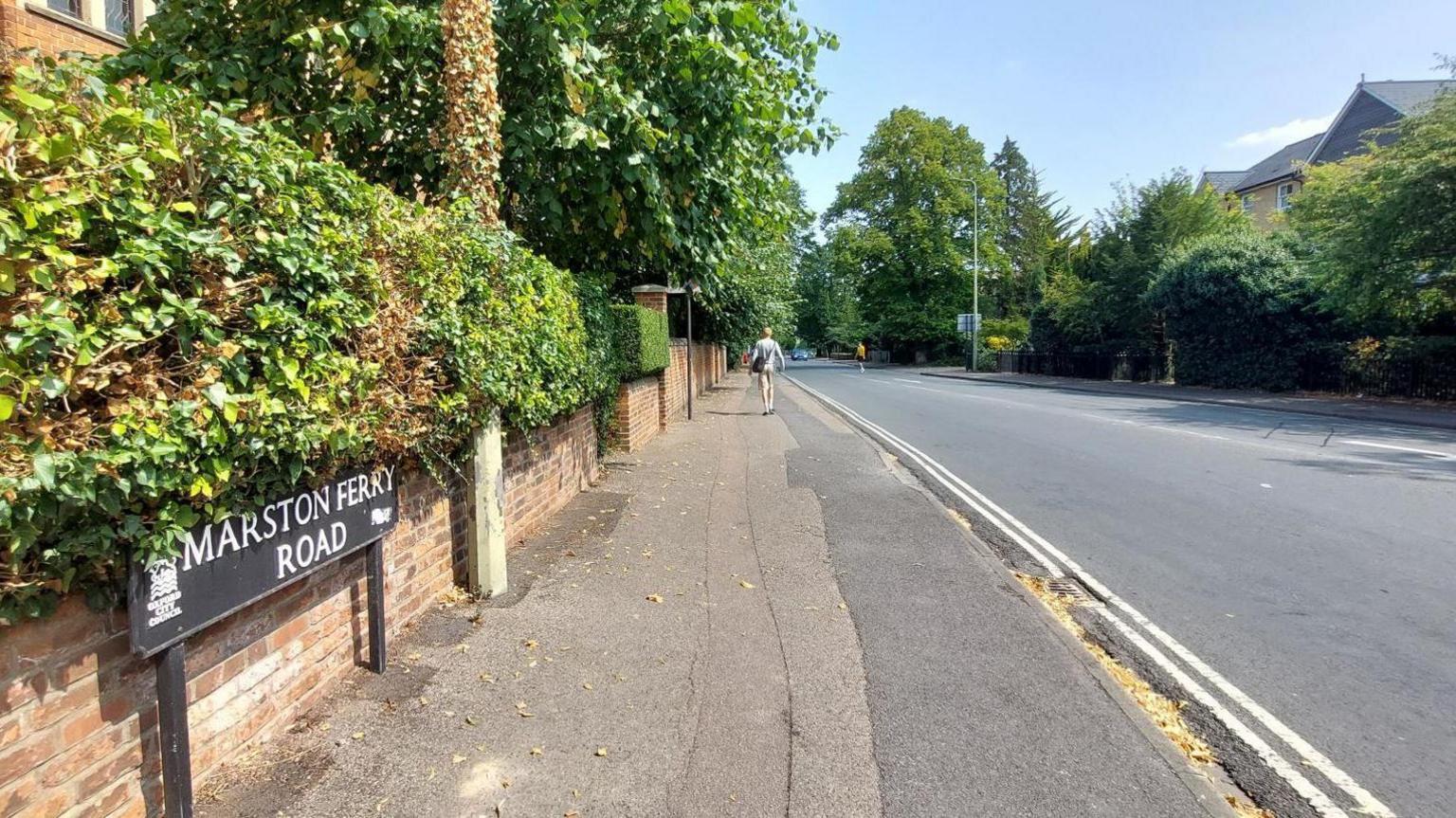 A black and white Marston Ferry Road sign sits in front of an empty run in the sunshine