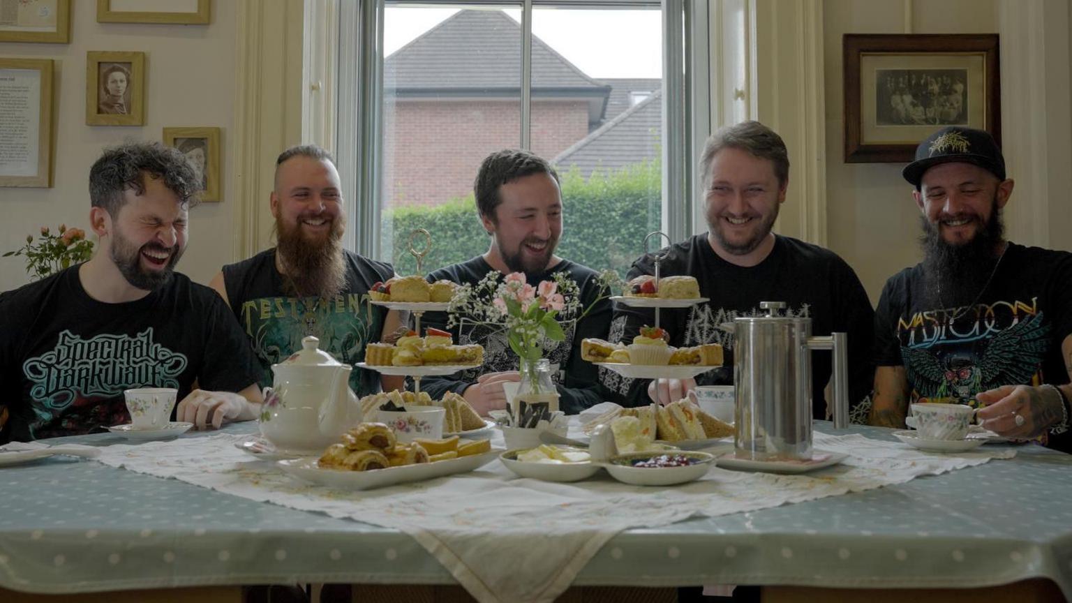 The band enjoy a joke while having afternoon tea