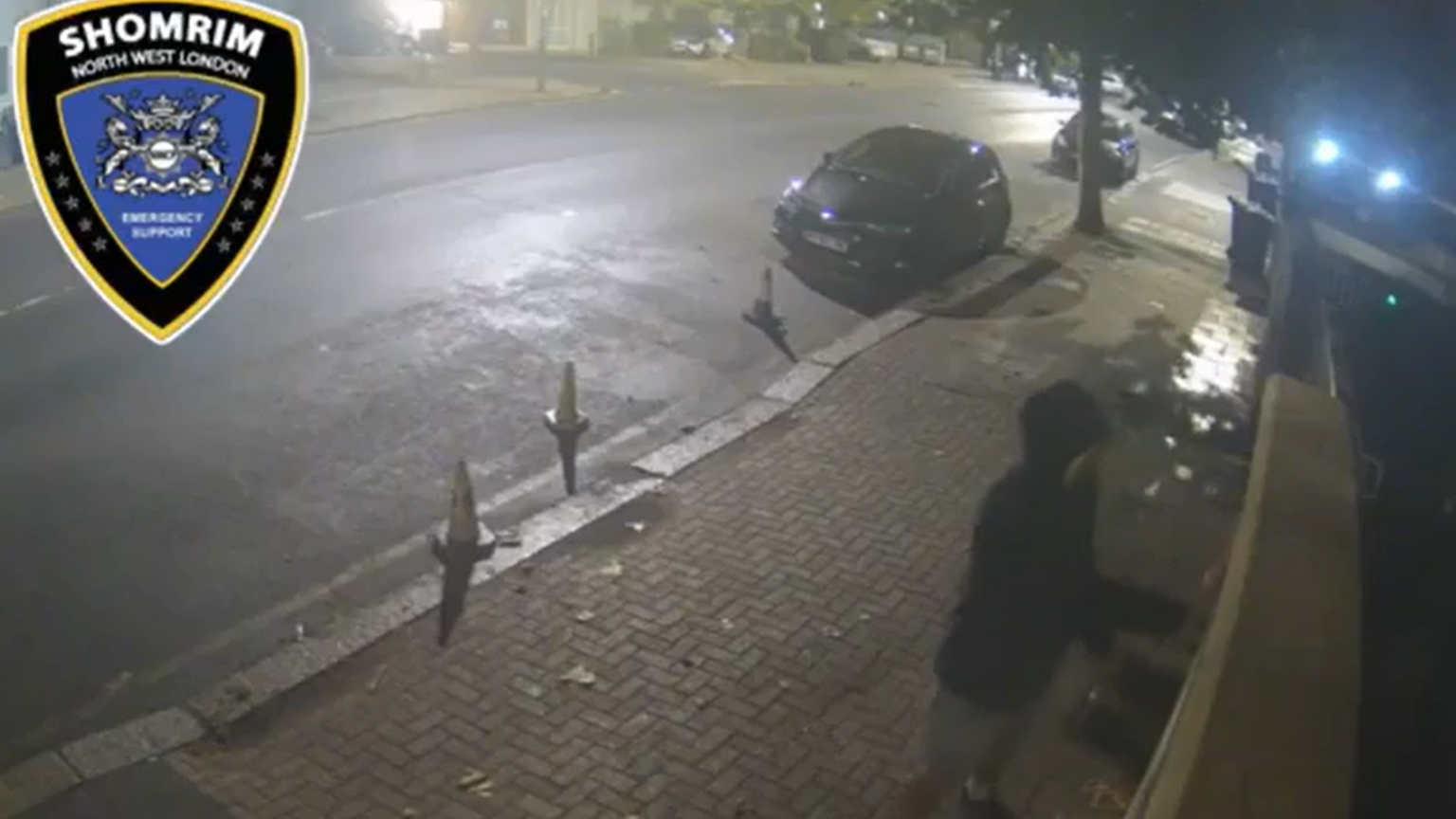 A CCTV image showing the man wiping something on a wall at night.
