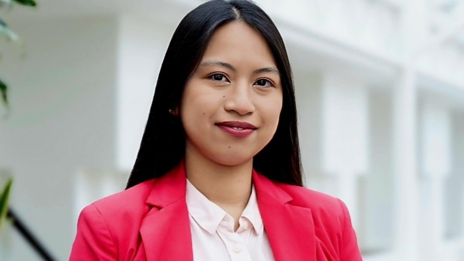 Danica Salazar, a woman with long black hair. She is wearing a light pink shirt and and darker pink jacket.