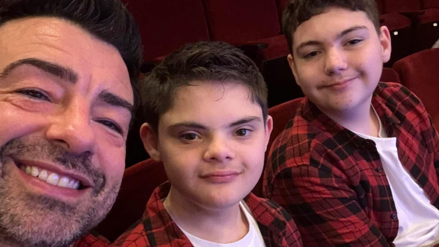 Dad Dominic is on the far left with his two sons. Lucas, 12, is in the middle and Alexander, 15, on the far right. They are all in matching white T-shirts and black and red chequered shirts. 