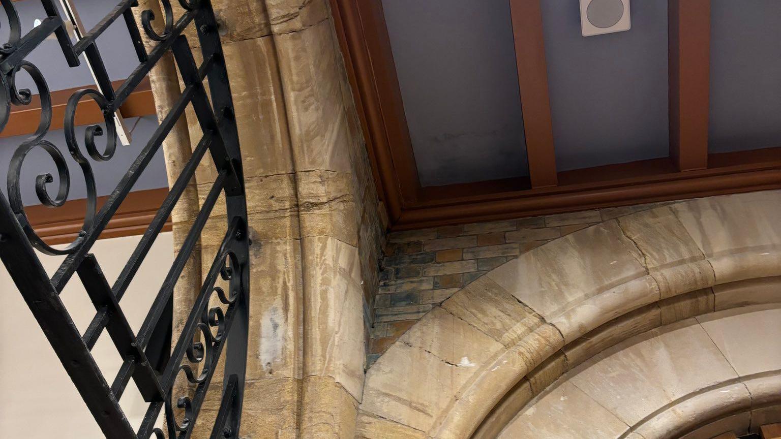 Image of the Lantern foyer roof at Bristol Beacon. Arches can be seen near the ceiling, as well as metal detailing. The leak is in the corner where the walls meet the roof. 