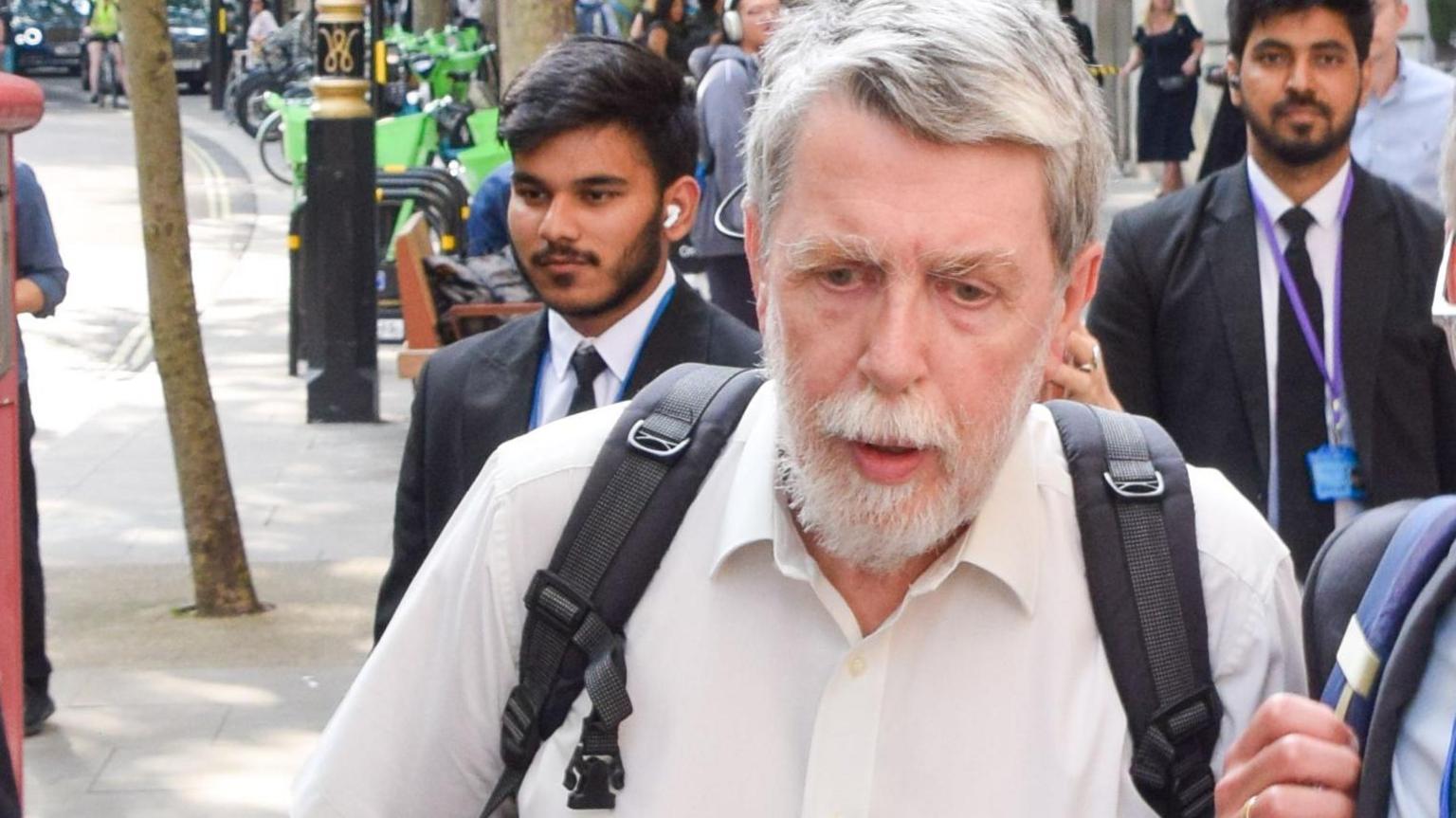 Gareth Jenkins wearing a white shirt and carrying a rucksack outside the Post Office Inquiry