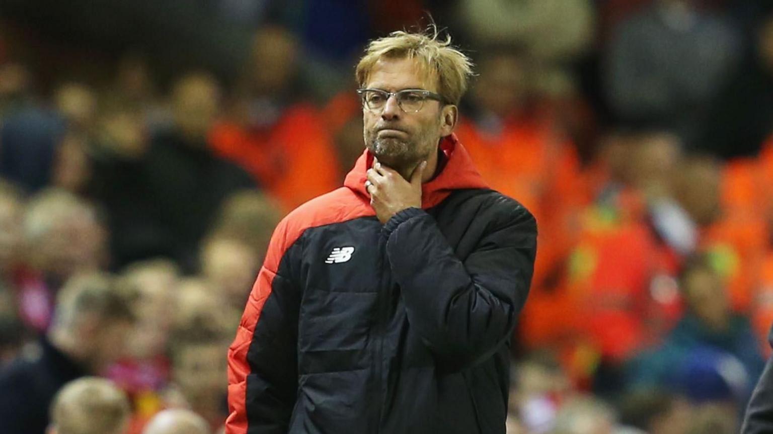Jurgen Klopp holds his throat while watching a Liverpool match