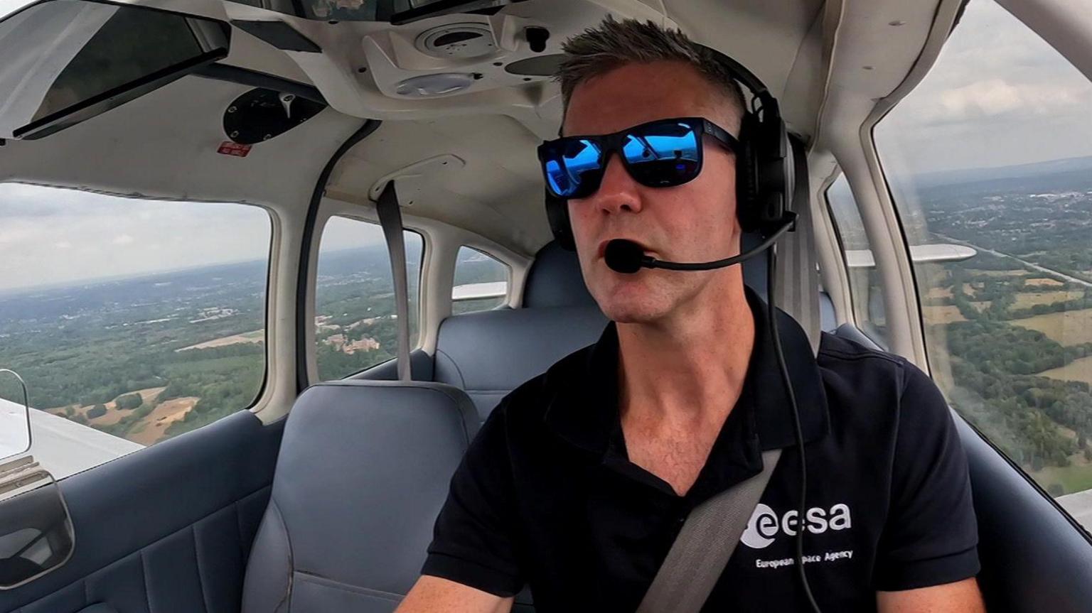John McFall flying a light aircraft, whilst wearing blue tinted sunglasses.