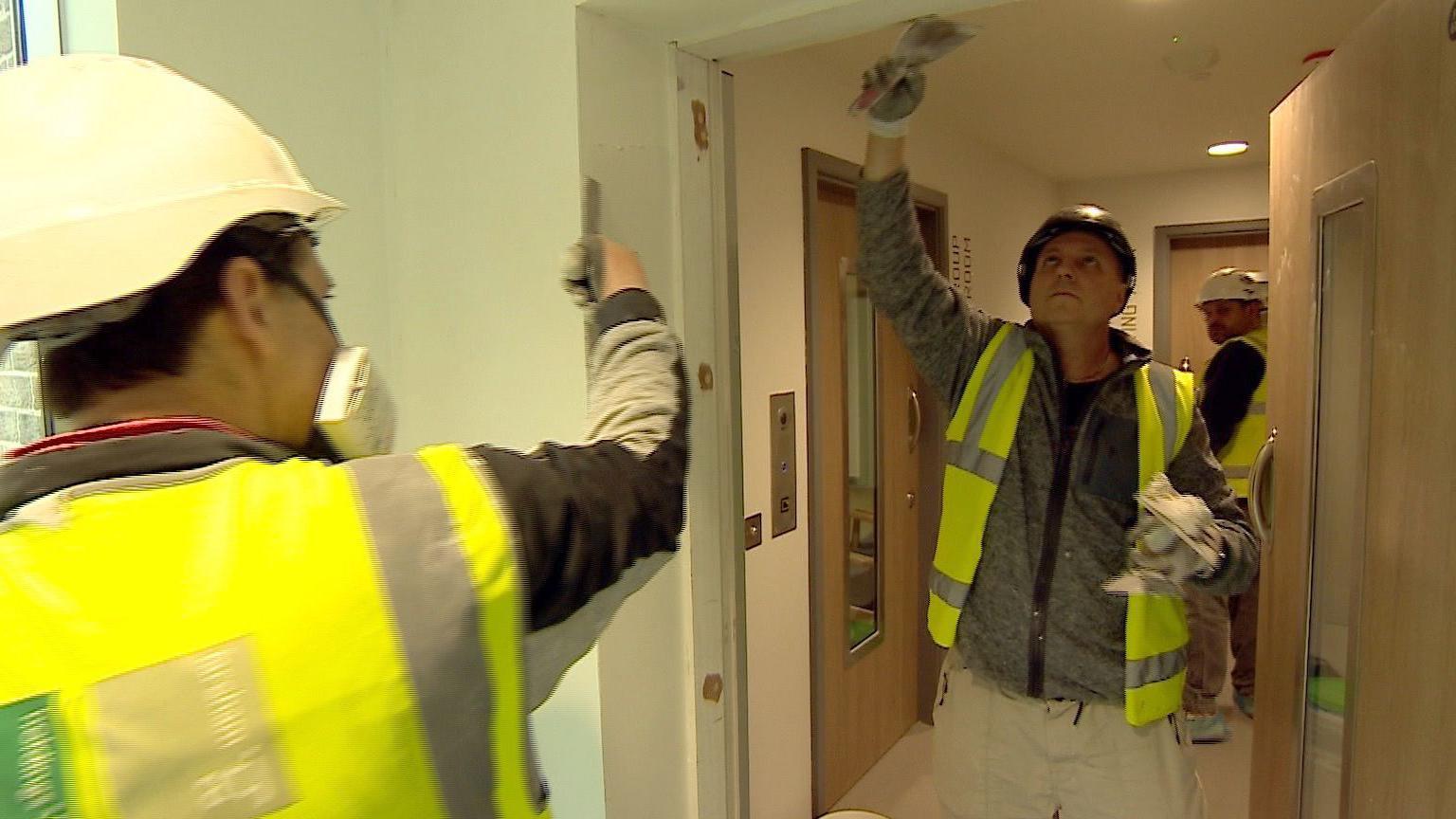 Plasterers making the final touches to the building