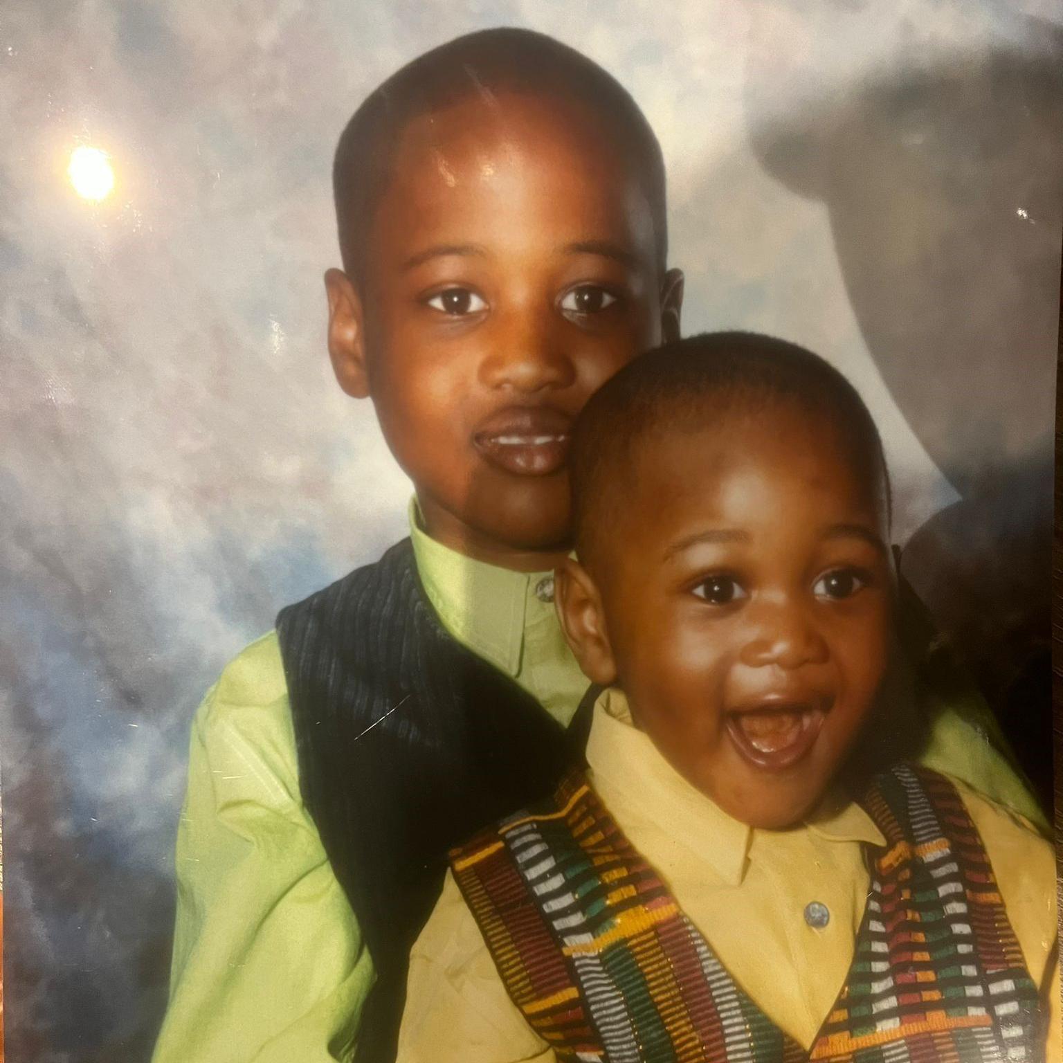 A family photo of Godwin Lawson holding his little brother Otis when they were young children