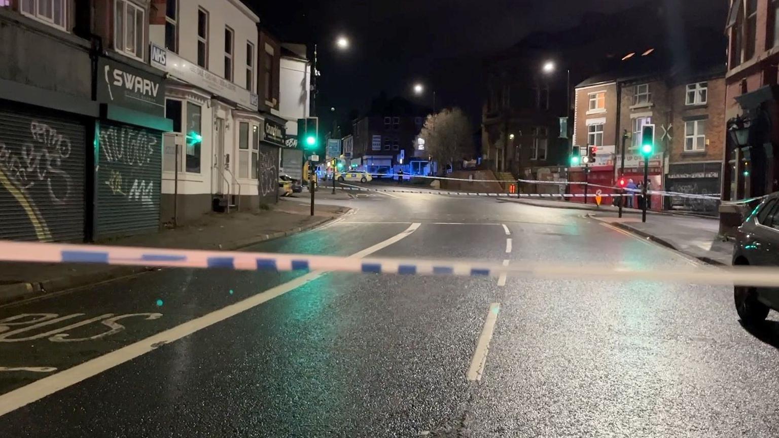 A police cordon on a residential street at night.