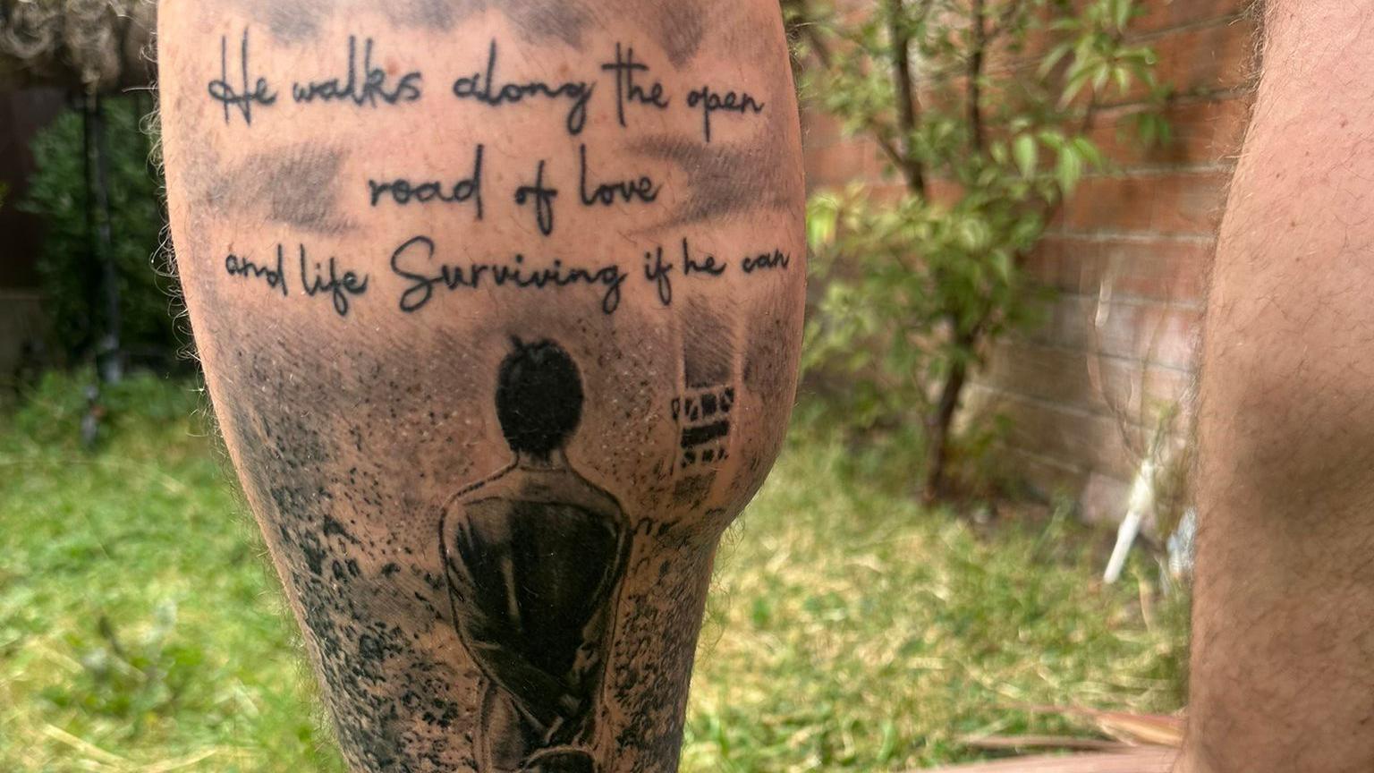 A tattoo on a man's calf featuring the back of Liam Gallagher's head and Oasis lyrics