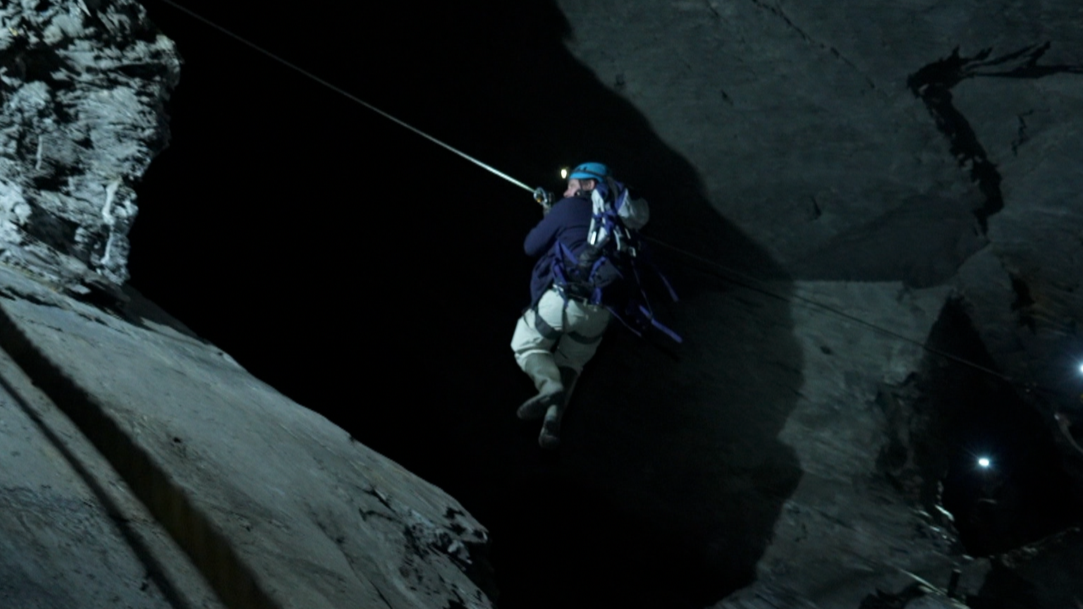 Reporter George Herd zips across a steep drop to reach another patch down the mine