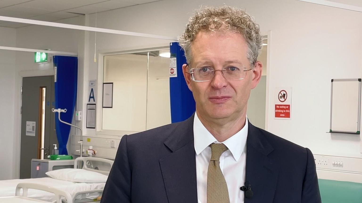 A man in a suit and tie in a medical training room 