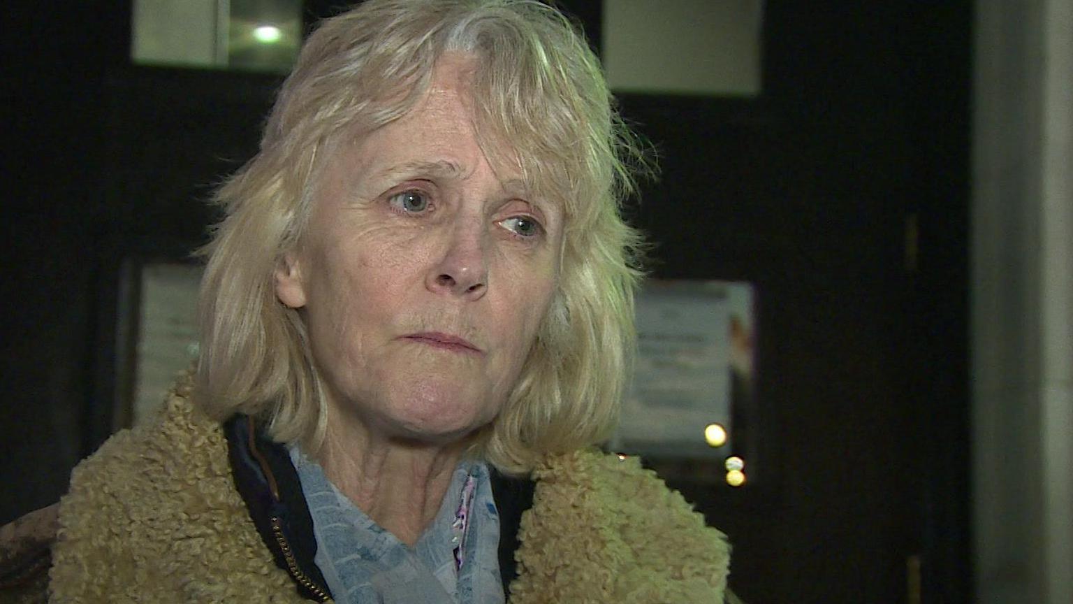 A serious looking Penny Bowen outside the tenants meeting. She has shoulder length blonde hair and is wearing a jacket with a sheepskin collar.