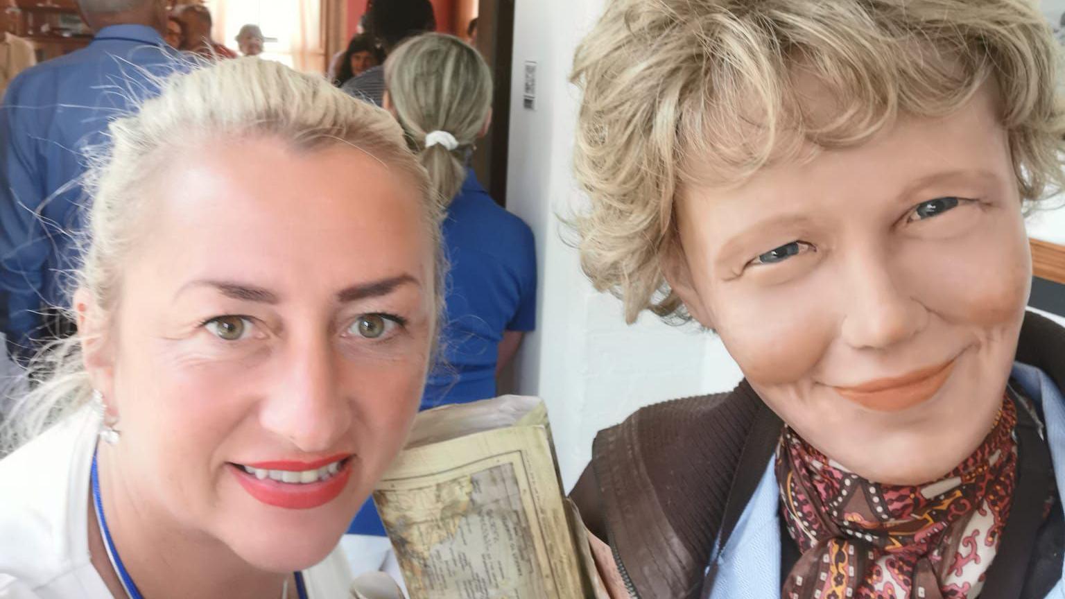 Nicole McElhinney stands alongside a waxwork of amelia earhart during a visit to the earhart birthplace musuem