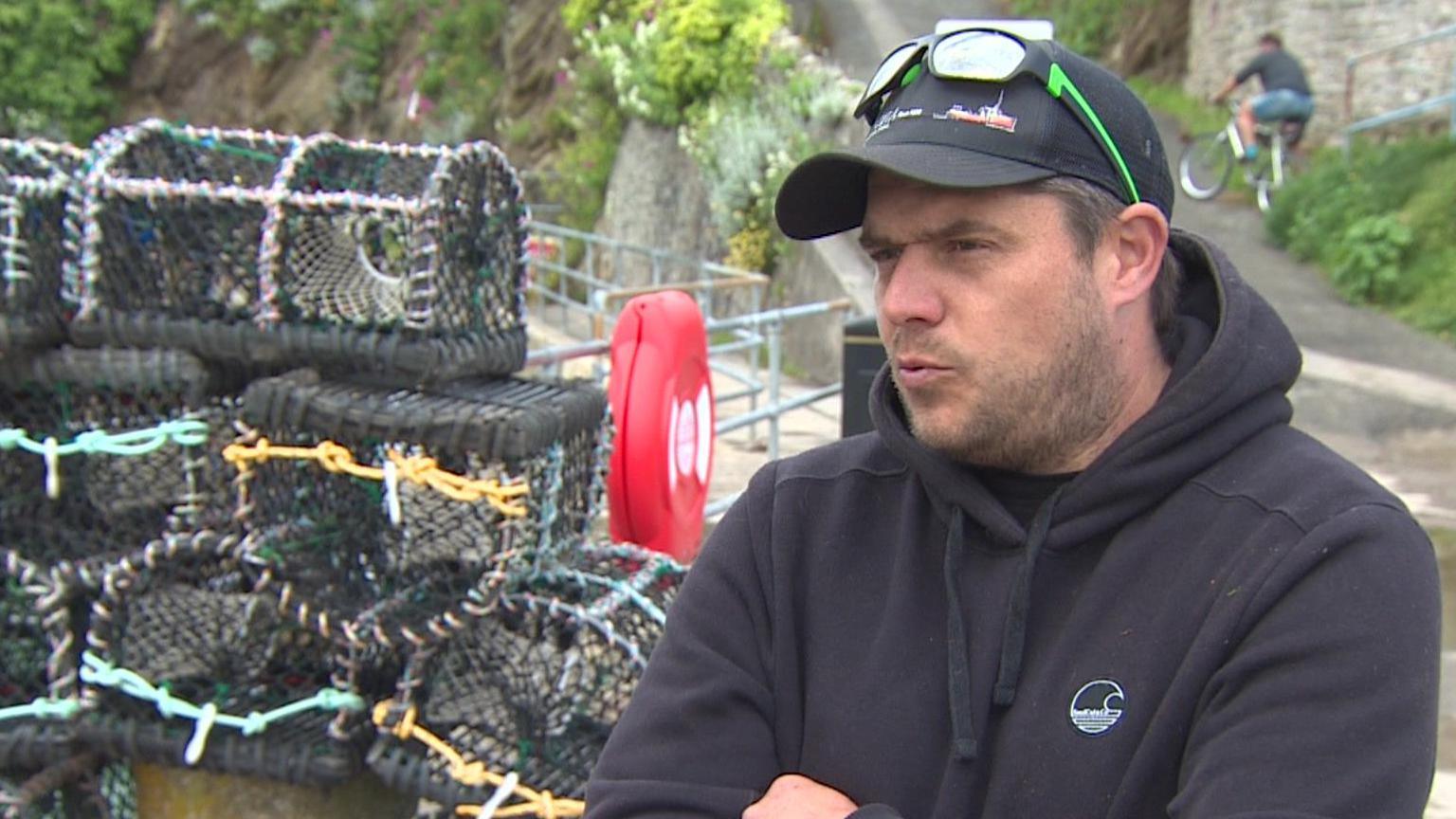 Man standing by crab pots 