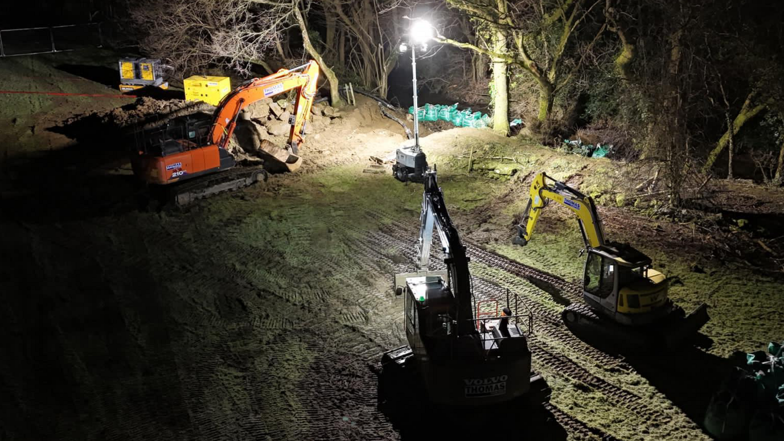 Diggers working in dark near river