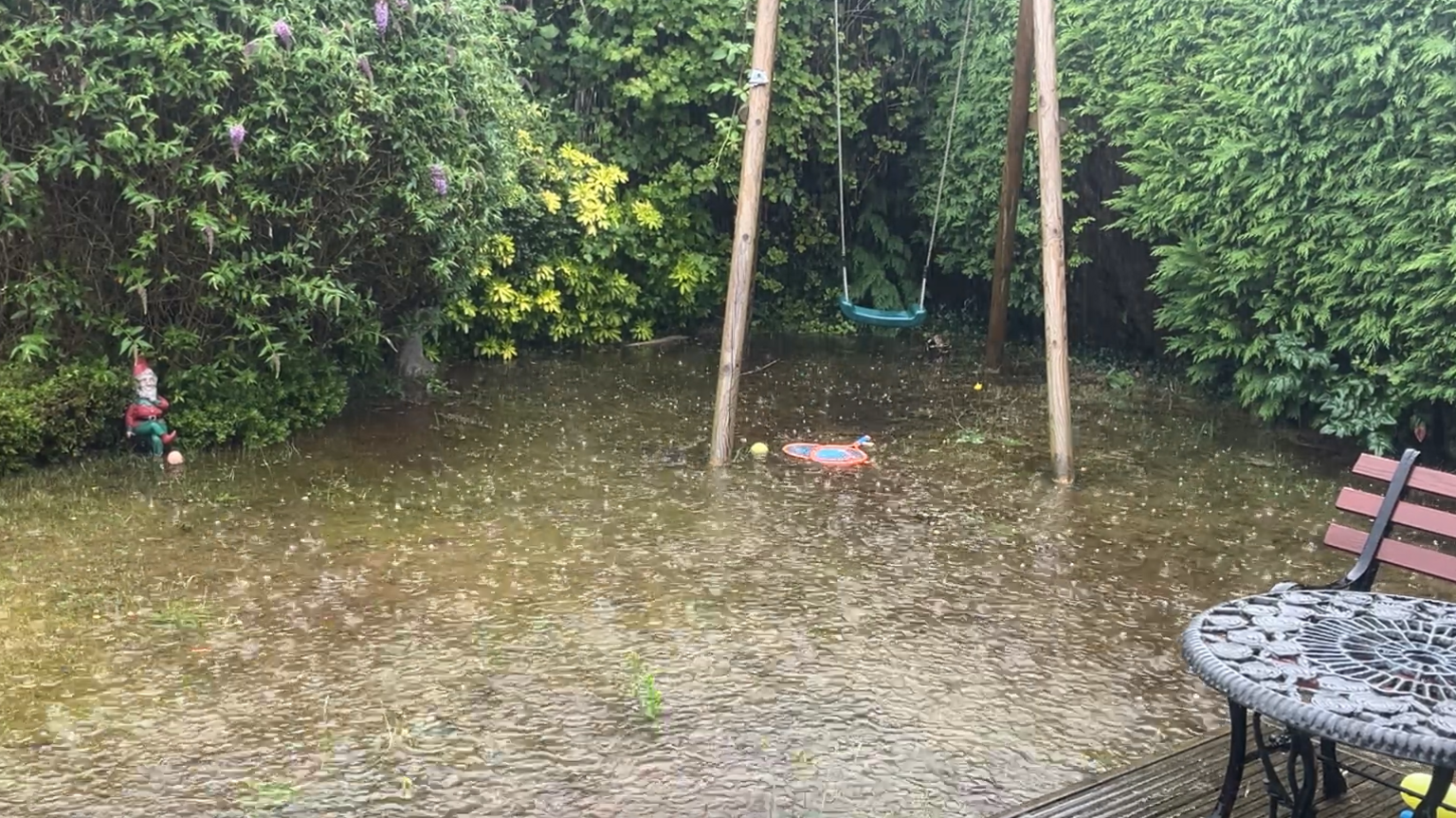 A garden is flooded as heavy rain falls.
