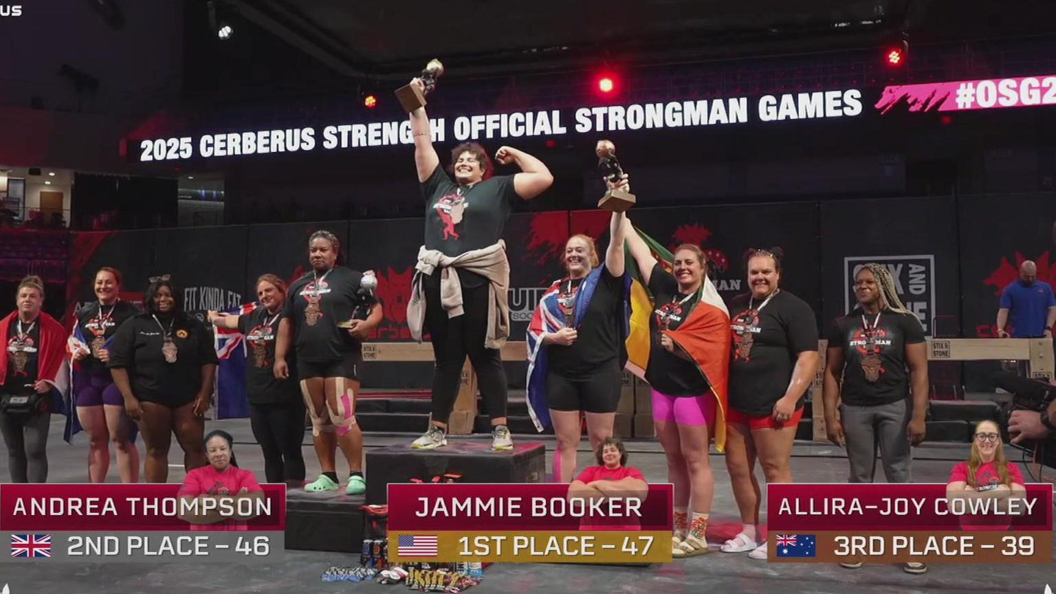 A group of athletes are stood connected and astir a podium aft nan world's strongest female competition. Jammie Booker is connected nan cardinal podium holding up a trophy.