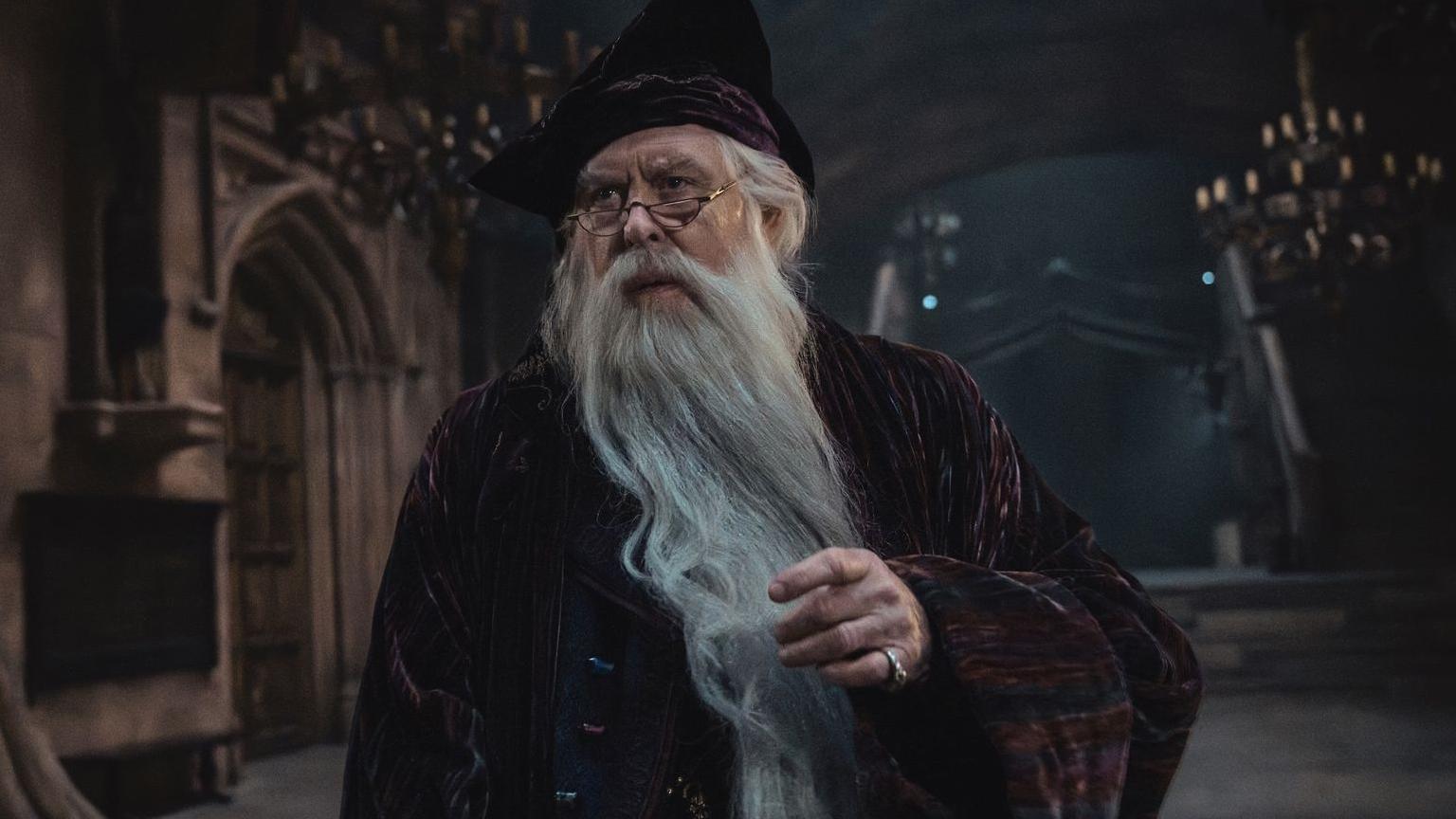 John Lithgow in a robe, hat and long grey beard