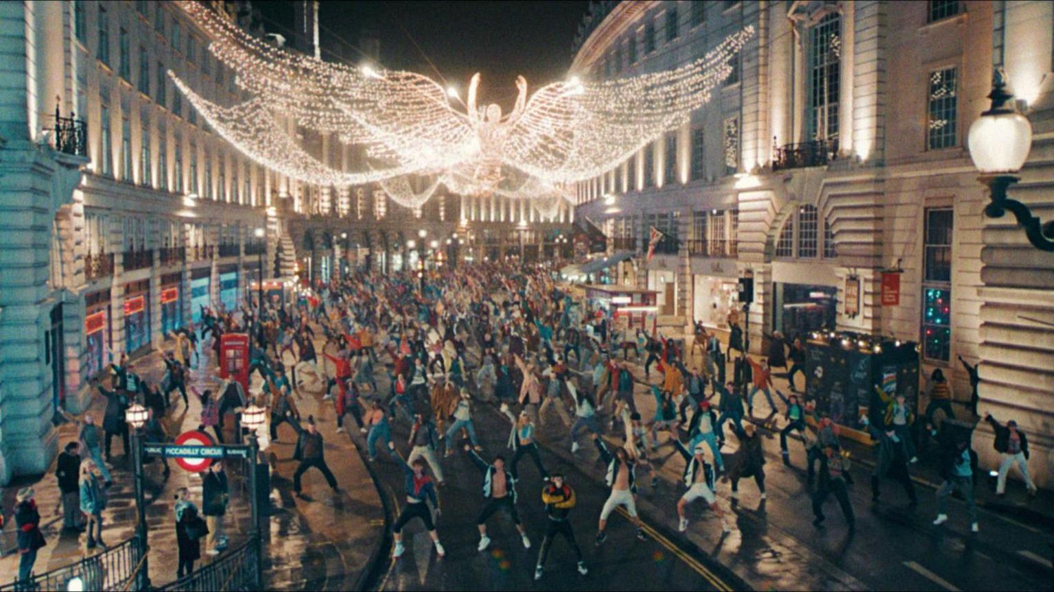 A scene from Better Man shows hundreds of dancers performing on London's Regent Street