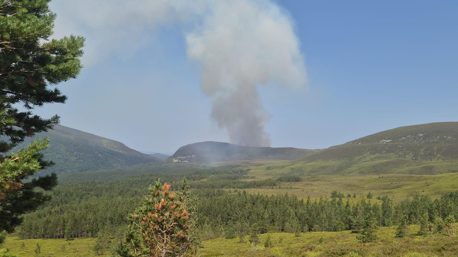 smoke spiralling over a hill