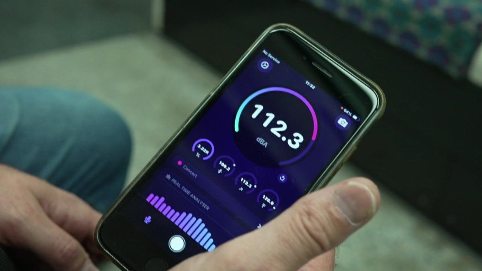 An app on a phone reading the figures 112.3 with some lines below analysing the reading of sound waves 