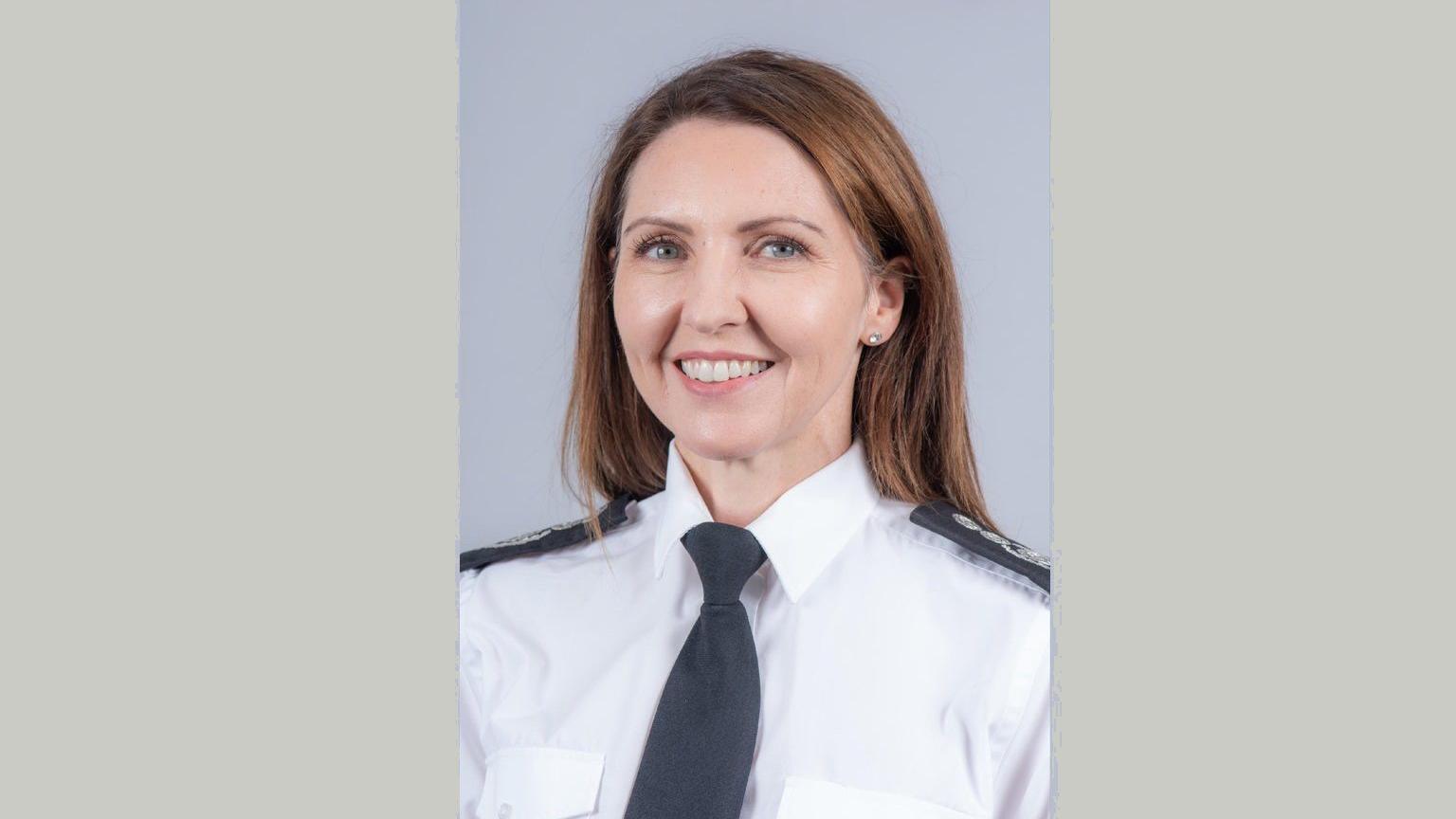 Keri Sumner is wearing her fire service dress uniform of a white shirt with dark tie.