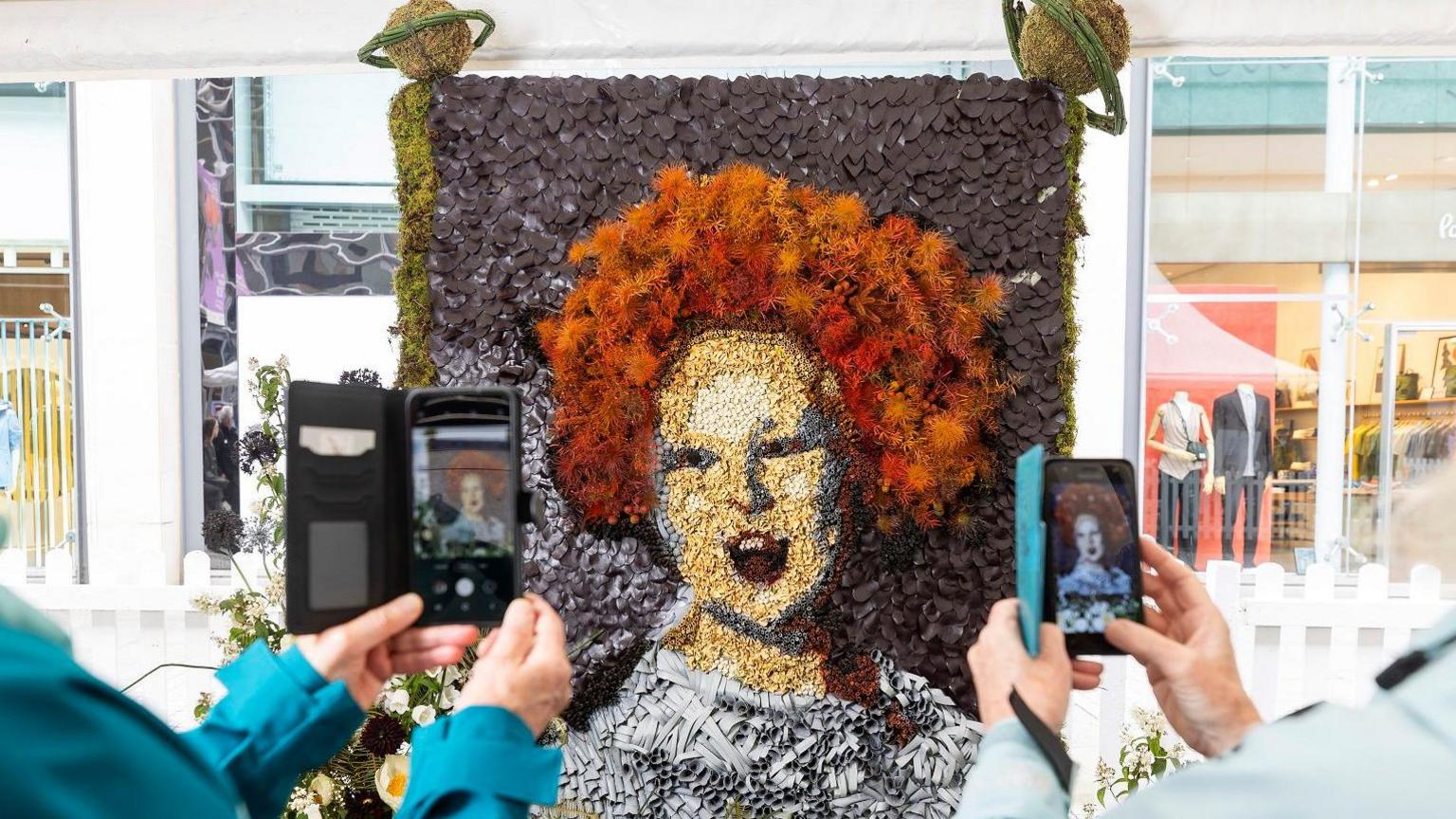 people taking images of Dame Vivienne Westwood floral art