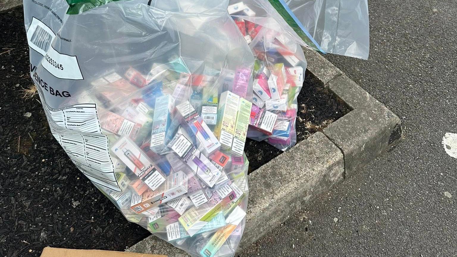 Vapes in their packaging in large plastic bags.