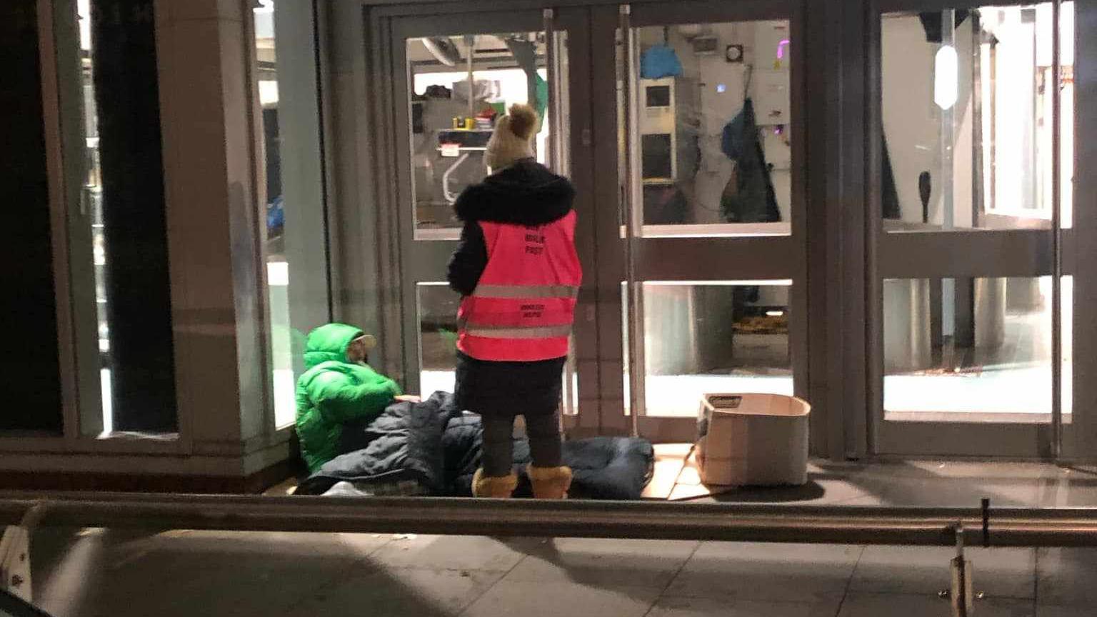 Charity volunteer helping rough sleeper in Manchester city centre