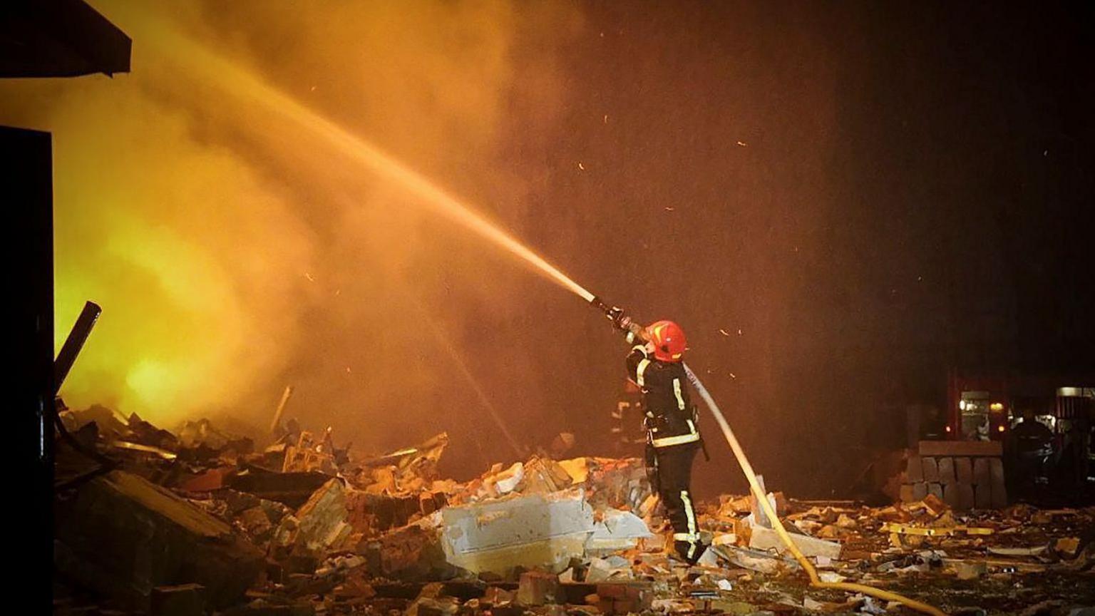 A firefighter extinguishes a building fire in Khmelnytskyi, Ukraine, in February 2023, in a photo provided by state rescue services.