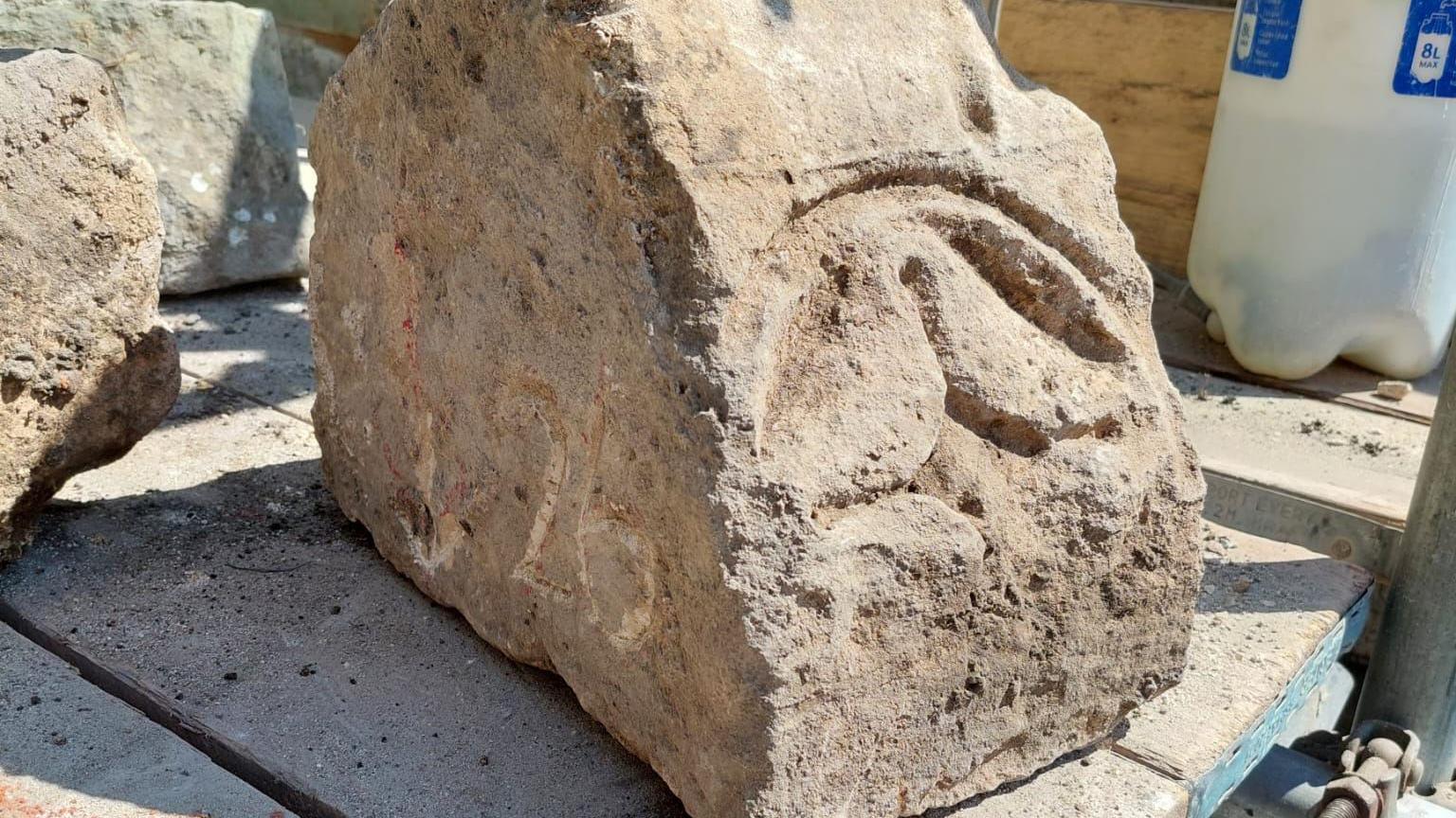 A large bit of stone with a circular carving with the cross in the middle