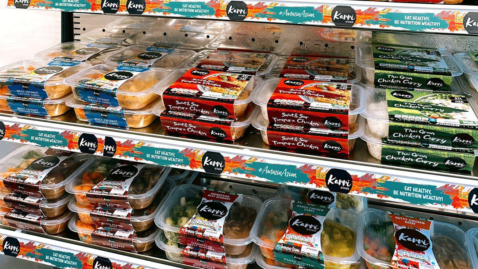 A range of ready meals across two shelves in a shop.